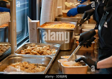 Non exclusif : volontaires du train alimentaire, qui fournit des repas chauds aux personnes laissées sans électricité et sans chauffage en raison d'une attaque russe, pack déjeuner Ser Banque D'Images