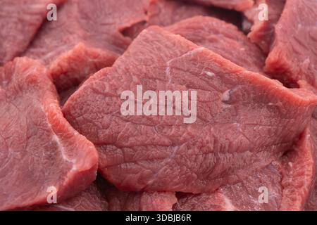 Viande de bœuf fraîche crue. Lamelles de bœuf de viande crue fraîche tranchée stroganoff isolées sur fond blanc. Banque D'Images