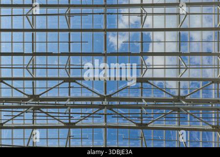 Vue d'en bas d'un grand plafond de verre avec des cadres contre le ciel. Banque D'Images