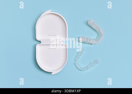 Protège-dents dentaires transparents personnalisés aligners clairs pour la mâchoire inférieure dans un boîtier blanc sur fond bleu Banque D'Images