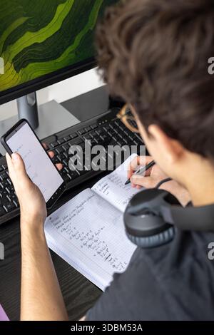Adolescent étudiant à la maison sur un ordinateur. Adolescent freelance travaillant sur un projet à la maison. Préparation de l'examen. Adolescent étudiant en ligne Banque D'Images