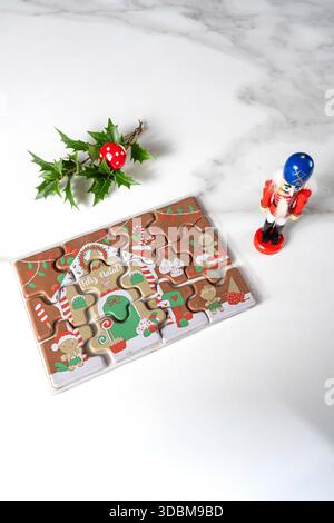 Puzzle au chocolat au lait à côté de la poupée casse-noisette et ornement de Noël vertical. Banque D'Images
