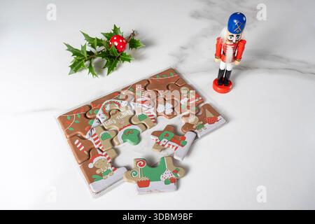 Puzzle au chocolat au lait à côté de la poupée casse-noisette et ornement de Noël. Banque D'Images