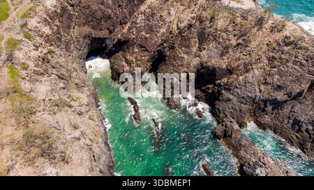 Vue aérienne des falaises escarpées embrassant les eaux turquoises près de Hell's Gates, créant une scène côtière spectaculaire, Noosa Heads, Queensland, Australie Banque D'Images