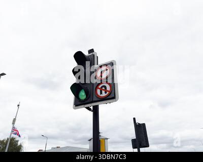 Carrefour urbain à Manchester montrant un feu vert et des panneaux de virage interdits. Banque D'Images