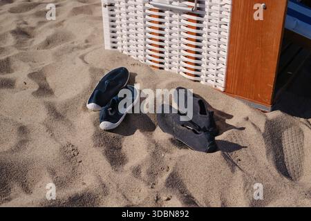Chaussures d'eau sur la plage à côté de la chaise de plage Banque D'Images