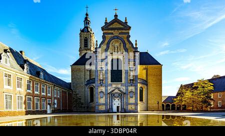 Paysage architectural avec impressionnante façade de l'abbaye d'Averbode dans le style baroque, sculptures et clocher, étang avec reflet dans la surface de l'eau dans Banque D'Images