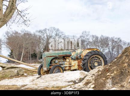 vieux tracteur agricole d'occasion assis dans un paysage d'hiver à riverhead, ny Banque D'Images