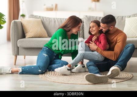 Happy Arab Family profitant de moments ludiques à la maison tout en chatouillant leur fille Banque D'Images