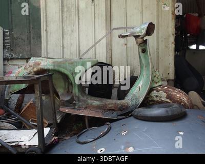Un corps de cadre vert d'un vieux scooter rétro vintage classique, un corps rustique avec de la peinture dépouillée de quelques ordures et objets indésirables. Banque D'Images
