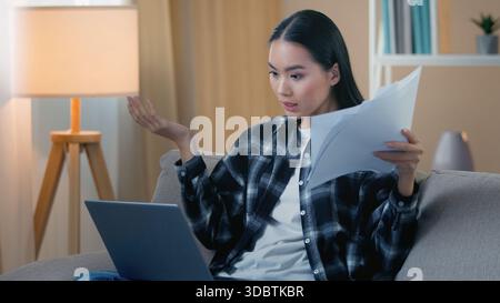 La femme d'affaires coréenne en colère stressée asiatique à la maison se disputant sur un ordinateur portable d'appel vidéo frustrée femme d'affaires fille freelance patron dispute discussion Banque D'Images