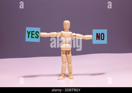 Une personne tient deux pièces de puzzle, dont l'une dit «oui» et l'autre «non». Concept de prendre une décision ou de choisir entre deux options Banque D'Images