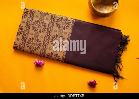Saree de coton plié de l'érode, Tamil Nadu, Inde sur fond jaune Banque D'Images