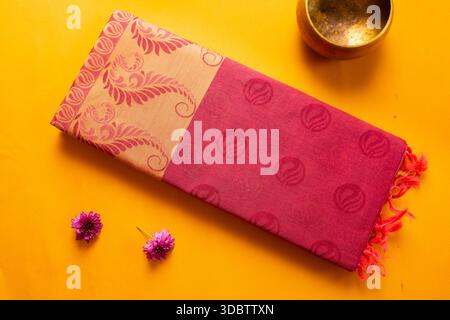 Saree de coton plié de l'érode, Tamil Nadu, Inde sur fond jaune Banque D'Images