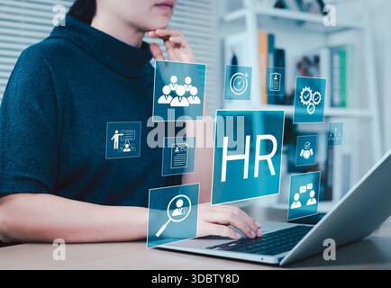 RH, GRH, concept de gestion des ressources humaines. Femme d'affaires travaille sur ordinateur portable avec l'icône RH représentant les ressources humaines, le recrutement, la formation, l'employé i. Banque D'Images