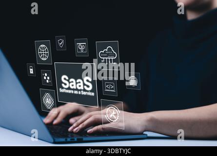 Cloud Computing SaaS et concept de logiciel en tant que service. Une personne utilisant un ordinateur portable avec des icônes d'interface virtuelle montrant SaaS, cloud computing, IA, etc Banque D'Images