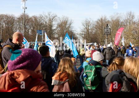 Berlin, Allemagne, 18 décembre 2025. Les employés du secteur public et les membres de la DPolG (Deutsche Polizeigewerkschaft) se rassemblent pour une grève et un rassemblement de protestation à grande échelle à la porte historique de Brandebourg. Des manifestants portant des gilets promotionnels blancs et portant de grands drapeaux syndicaux blancs et bleus se tiennent devant les colonnes emblématiques de Pariser Platz. Les participants s'engagent dans des discussions pendant la manifestation pour de meilleures conditions de travail, des salaires équitables et des réformes de la fonction publique. Cette image d'archive documente l'activisme syndical dans la capitale allemande. Crédit : Felix Wolf/Alamy Live News Banque D'Images