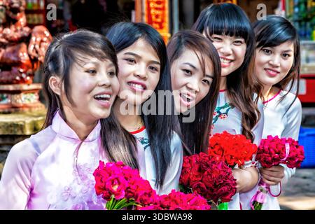 Groupe de filles vietnamiennes portant ao dai posant pour photo au Temple de la littérature, Hanoi, Vietnam Banque D'Images