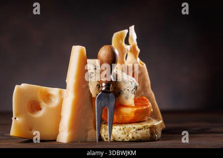 Fromages assortis de différentes formes et textures affichés ensemble sur une surface rustique Banque D'Images