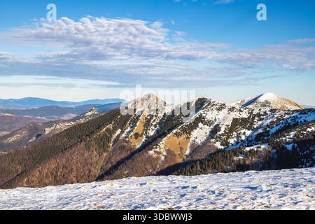 Chaîne de montagnes enneigée sous un ciel bleu. Le parc national de Mala Fatra au nord-ouest de la Slovaquie, en Europe. Banque D'Images