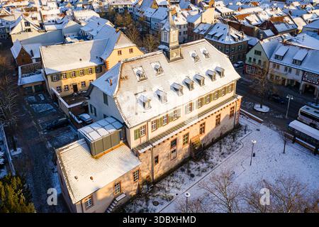 Vue aérienne des toits et des bâtiments enneigés, y compris l'historique Pfälzer Schloss, projetant de longues ombres sous un soleil d'hiver, Groß-Umstadt, Hess Banque D'Images