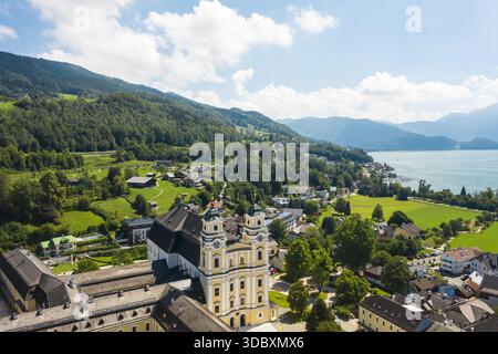 Vue aérienne de la superbe Basilique de Michael contrastant avec le paysage verdoyant et le serein lac Mondsee, Mondsee, haute-Autriche, Aus Banque D'Images
