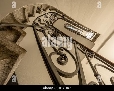 Admirez un escalier en colimaçon historique orné de fer forgé dans un ton sépia Banque D'Images