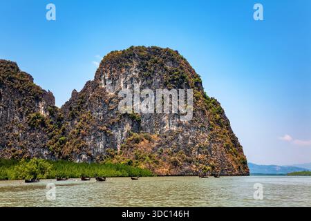 Îles rocheuses, baie de Phang Nga, mer d'Andaman, Thaïlande. Bateaux traditionnels dans la baie de Phang Nga. Banque D'Images