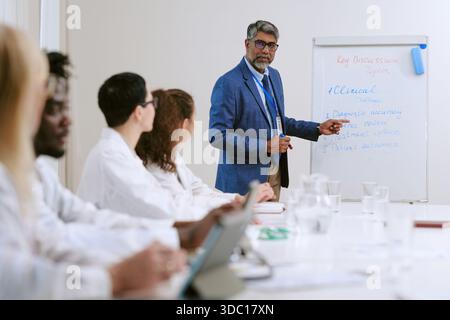 Réunion de l'équipe médicale d'un homme d'âge moyen pour discuter de sujets cliniques Banque D'Images