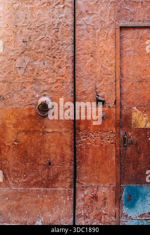 Vieille porte en métal rouillé avec anneau de fer frappant dans le centre-ville historique Banque D'Images