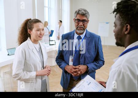 Des professionnels de la santé multiethniques discutent des soins aux patients à la réunion hospitalière Banque D'Images