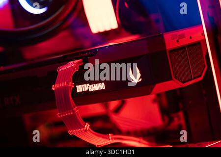 Rovigo, italie 18 décembre 2025 : gpu de jeu Zotac monté dans un boîtier de pc personnalisé avec rgb rouge brillant, câbles d'alimentation visibles, dissipateur thermique et ventilateur de refroidissement Banque D'Images