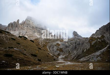 Les Dolomites brumeuses culminent au-dessus d'une vallée alpine en automne Banque D'Images