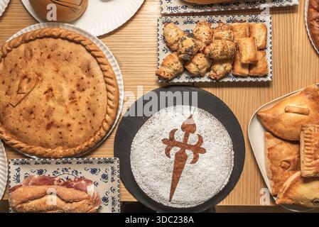 une empanada de morue avec des raisins secs et des pignons de pin, montrant l'épaisseur uniforme de la pâte et la garniture compacte, sur papier brun. Banque D'Images