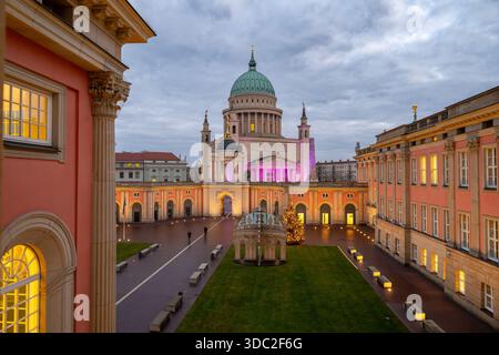 Potsdam, Allemagne. 18 décembre 2025. Un sapin de Noël décoré de lumières se dresse sur la toile de fond de l'église de Nicolas sur l'Alter Markt dans la cour intérieure du Landtag. Crédit : Soeren Stache/dpa/Alamy Live News Banque D'Images