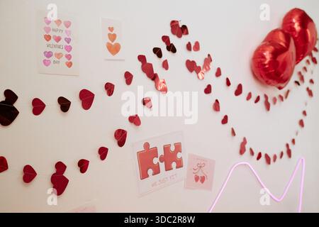 Décorations de coeur de Saint-Valentin accrochées au mur célébrant des vacances romantiques Banque D'Images