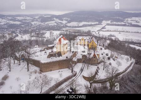 Vue aérienne du Schloss Reichenberg enneigé, ses murs anciens et ses tours majestueusement dressés sur la toile de fond des collines d'Odenwald, Rei Banque D'Images