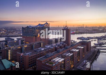 Vue aérienne de la salle de concert Elbphilharmonie et des bâtiments en briques reflétant le coucher de soleil sur l'Elbe, Hambourg, Hambourg, Allemagne. Banque D'Images