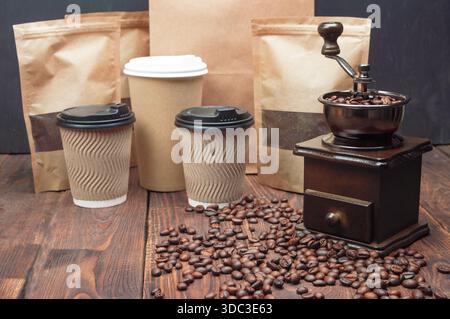 Grains de café torréfiés dans le moulin à café sur la table en bois Banque D'Images