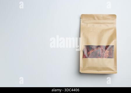 Pochette debout avec des piments secs sur fond clair, vue de dessus. Espace pour le texte Banque D'Images