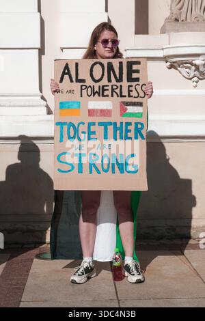 Femme tenant une pancarte de solidarité indiquant « seuls, nous sommes impuissants, ensemble, nous sommes forts » lors d’une manifestation pro-palestinienne à Varsovie. Banque D'Images