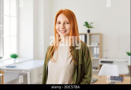 Portrait d'Une femme rousse heureuse travaillant au Bureau Banque D'Images