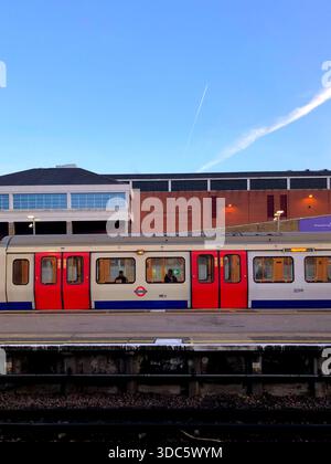 Un train de la ligne S7 Stock District à Wimbledon Station, Londres avec une vue sur le quartier de Wimbledon derrière elle par une journée ensoleillée Banque D'Images