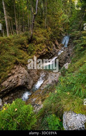 Une cascade tranquille coule gracieusement à travers des rochers couverts de mousse et une végétation vibrante évoquant la paix et la beauté naturelle dans Autrichias immaculé Gadental v Banque D'Images