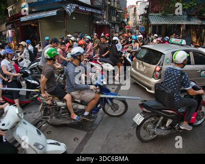 hanoi-Vietnam-10 août 2019, dense embouteillage avec de nombreuses motos et scooters traversant les voies ferrées dans une zone urbaine animée de Hano Banque D'Images