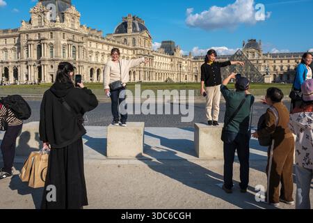 Touristes posant pour des photos devant la pyramide du Louvre, Paris, France Banque D'Images