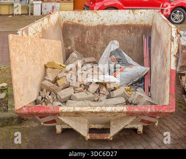 conteneur de déchets de construction rempli de gravats se trouve à l'extérieur sur la rue Banque D'Images