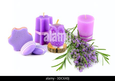 Spa relaxant avec bougies violettes, branches de lavande et savon sur fond blanc. Banque D'Images