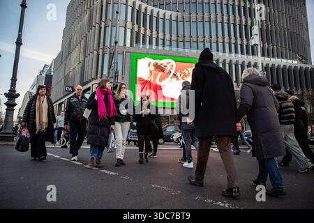 Berlin, Berlin, Allemagne. 20 décembre 2025. Les piétons traversent l'intersection entre Joachimsthaler Strasse et Kurfuerstendamm à Berlin le samedi 20 décembre 2025, alors que les achats de dernière minute de Noël se poursuivent dans toute la ville. Les acheteurs transportant des sacs se déplacent à travers le passage à niveau occupé tandis que de grands affichages publicitaires se profilent derrière eux le long du boulevard commercial. L'activité de vente au détail s'est intensifiée dans les derniers jours avant les vacances, car les magasins prolongent les heures d'ouverture et les rues sont de plus en plus encombrées. Kurfuerstendamm reste l'un des principaux quartiers commerçants de Berlin pendant la période de Noël. (Crédit image : © M Banque D'Images