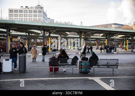 Berlin, Berlin, Allemagne. 20 décembre 2025. Les voyageurs attendent des bus longue distance à la gare routière centrale (ZOB) de Berlin le samedi 20 décembre 2025, alors que les voyages de vacances augmentent avant Noël. Les passagers s'assoient avec leurs bagages alors qu'ils se préparent à partir pour des destinations à travers l'Allemagne et à l'étranger pour se réunir avec leur famille et leurs amis pour les vacances. Le ZOB, situé dans le district de Westend près de Funkturm, dessert exclusivement le trafic de bus longue distance et est une plaque tournante clé pour les voyages nationaux et internationaux en autocar. Le terminal exploite des dizaines de plates-formes utilisées par les bus réguliers et affrétés Banque D'Images